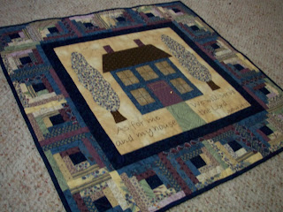 wallhanging with appliqued house and log cabin border