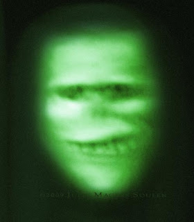 green glowing ghostly face with malevolent grin