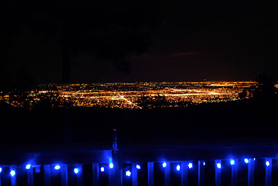 A night landscape of city lights and blue lights on a deck.