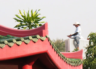 Worker on the roof behind the Karon Plaza temple