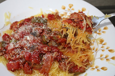 bowl of spaghetti squash covered in turkey vegetable ragu with a fork taking some from the dish