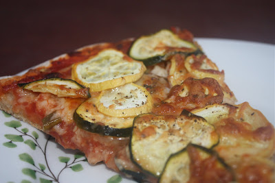 plate of pizza sliced topped with squash and zucchini 