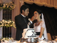 a photo of Yasir, the groom feeding Aainna, the bride during the cake cutting ceremony