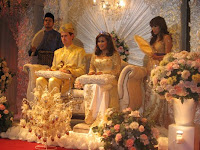 Bridal couple Farah and Matthew sitting at the pelamin