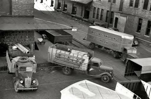 September 1939. Minneapolis, Minnesota. Trucks loading at farm implement warehouse