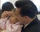 Dân biểu Cao Quang Ánh giúp con làm dấu thánh giá trong nhà thờ