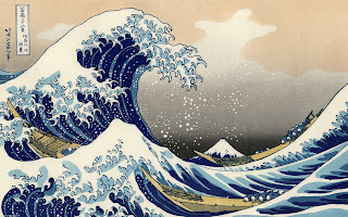 Japanese style silk painting of large waves with mountain peak in background in blues and browns