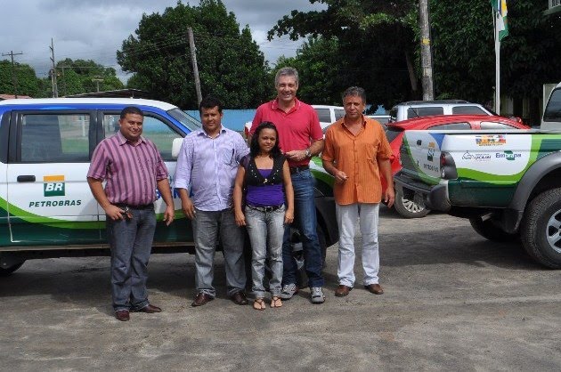 Autoridades e representantes durante a entrega. No detalhe um dos veículos recebidos