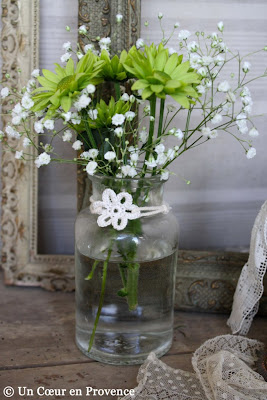 Some flowers mixed with sprigs of gypsophilia in a old glass bottle