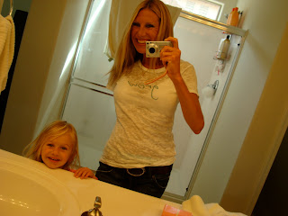 Woman and child taking picture in bathroom mirror