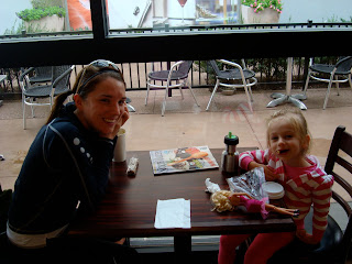 Woman and young girl sitting at table smiling 