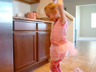 Young girl dancing in kitchen wearing tutu
