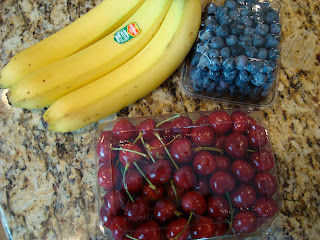 Cherries, bananas and blueberries on countertop