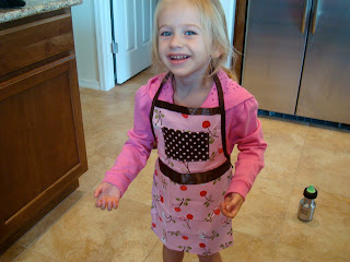 Young girl wearing apron in kitchen