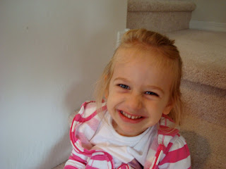 Young girl smiling for camera on steps