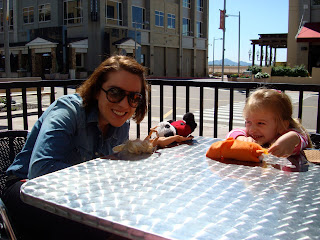 Woman and young girl sitting at a table outside of coffee shop