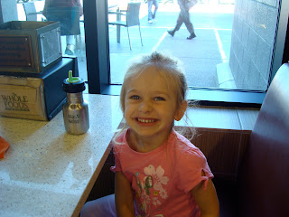 Little girl sitting in booth smiling