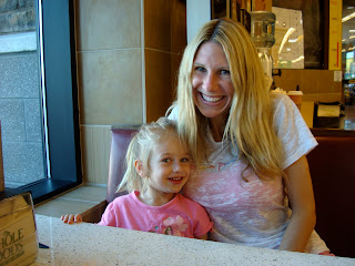 Woman and young girl sitting in booth smiling