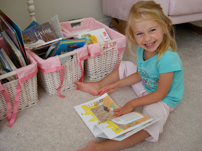Young girl smiling while looking at book