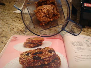 Open cookbook with oatmeal raisin cookie mixture in blender