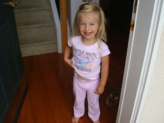 Little girl smiling in her pajamas in doorway