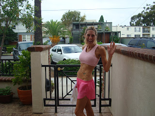 Woman in running attire in front of gate waving