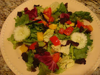 Mixed vegetable and greens salad in shallow white bowl
