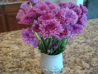 Vase of purple flowers on countertop - 19