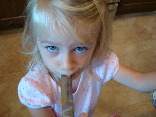 Young girl sucking Sunflower Seed Butter off of butter knife