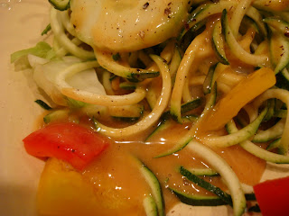 Spiralized zucchini on plate showing pooling of peanut sauce