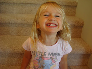 Photo of young girl giving big smile in front of staircase