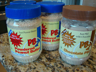 Three containers of Peanut Butter Powder one being Chocolate