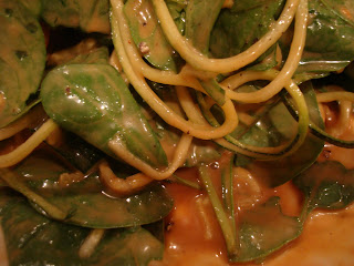 Close up of Spinach and Noodles with dripping peanut sauce