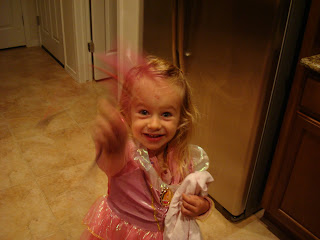 Young girl in fairy princess costume standing in kitchen