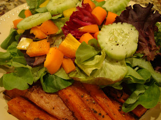 Simple vegetable salad served alongside sweet potato fries