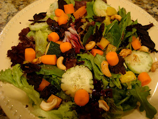 Mixed green salad with vegetables on white plate