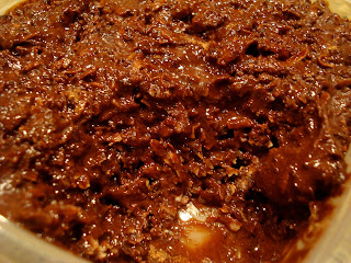 Raw Vegan Chocolate Coconut Snowballs in clear container with scoop taken out