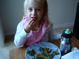 Young girl putting one Kale Chip in mouth