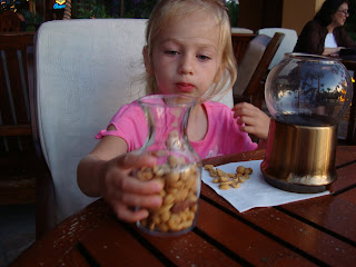 Young girl eating a jar of mixed nuts