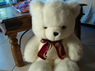 White Teddy Bear sitting in chair