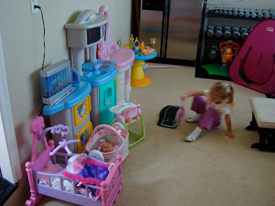 Toy room with multiple toy set ups and young girl playing