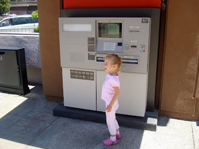 Young girl standing by ATM machine