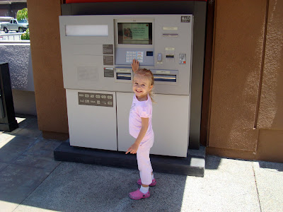 Young girl at ATM machine smiling
