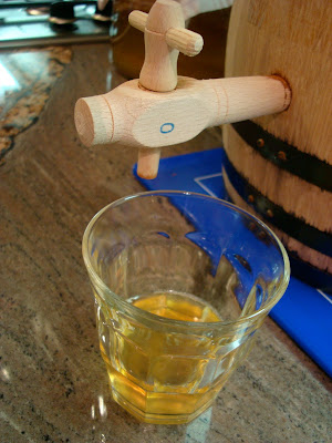 Oak barrel tap with glass of kombucha underneath