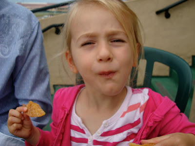 Young girl looking at camera eating chips