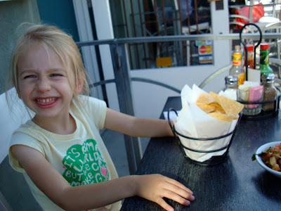 Young girl with hands on table with chips in front of her