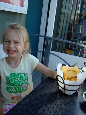 Young girl sitting at table next to chips