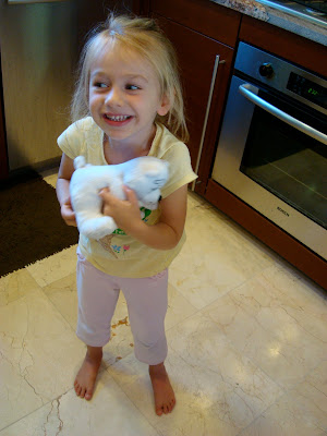 Young girl in kitchen holding toy