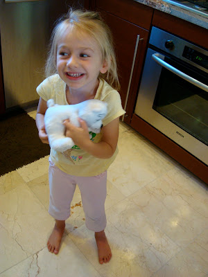 Young girl in kitchen holding toy - 15