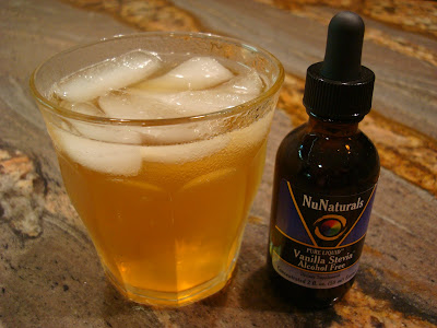 Glass of kombucha with ice next to bottle of liquid vanilla stevia